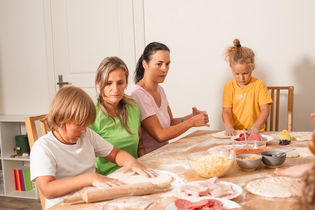 The educators together with preschoolers make pizza