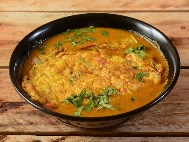 Egg Curry omelet is special indian spicy food served in a ceramic bowl over rustic wooden background Selective focus