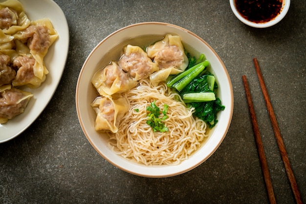 egg noodles with pork wonton soup or pork dumplings soup and vegetable - Asian food style