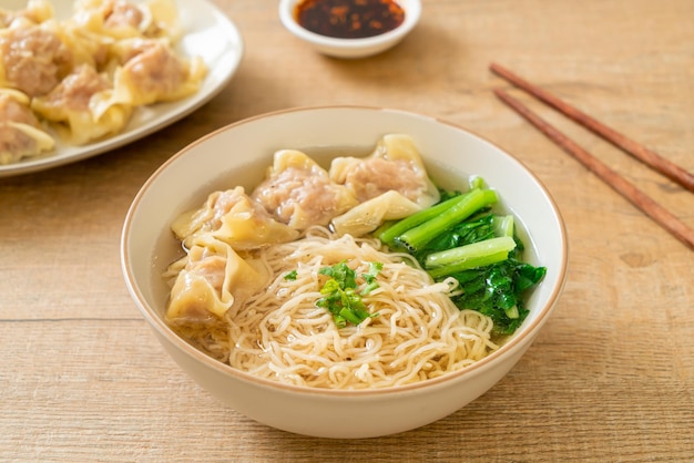 egg noodles with pork wonton soup or pork dumplings soup and vegetable - Asian food style