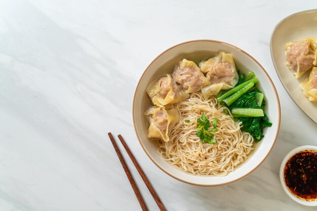 egg noodles with pork wonton soup or pork dumplings soup and vegetable - Asian food style