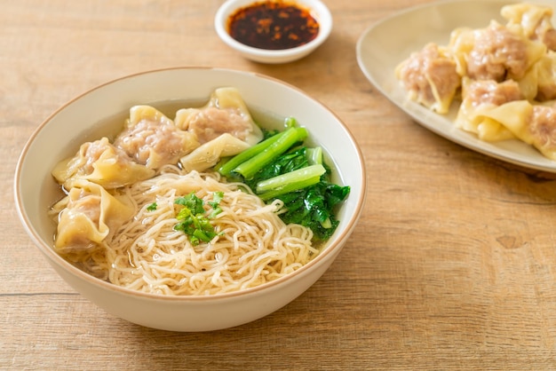 egg noodles with pork wonton soup or pork dumplings soup and vegetable - Asian food style