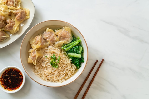 egg noodles with pork wonton soup or pork dumplings soup and vegetable - Asian food style