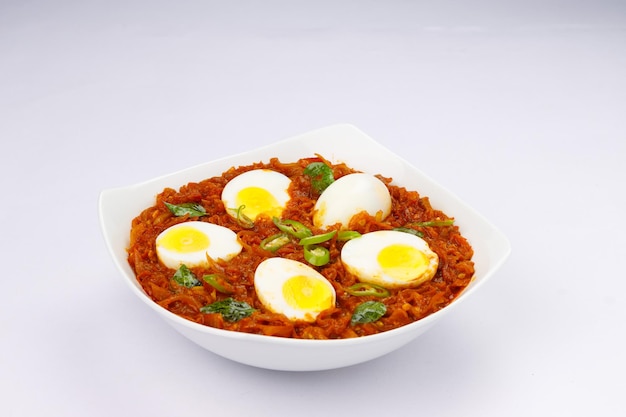 Egg roast or Indian egg masala curry spicy red egg roast arranged in a white ceramic bowl