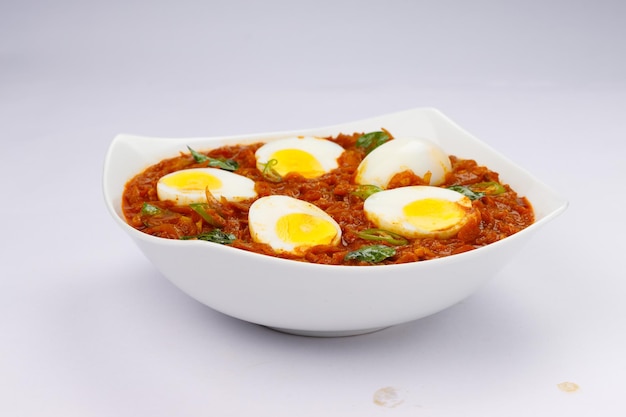 Egg roast or Indian egg masala curry spicy red egg roast arranged in a white ceramic bowl