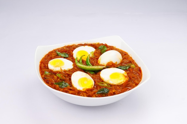 Egg roast or Indian egg masala curry spicy red egg roast arranged in a white ceramic bowl