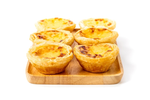 Egg tart the delicious crispy bekery on wooden plate isolated on white background