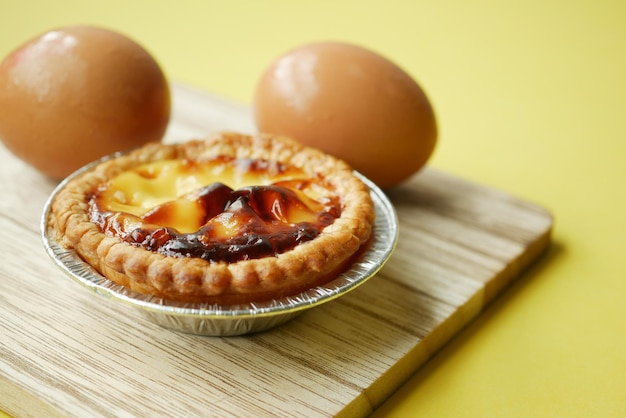 A egg tart on a wooden board