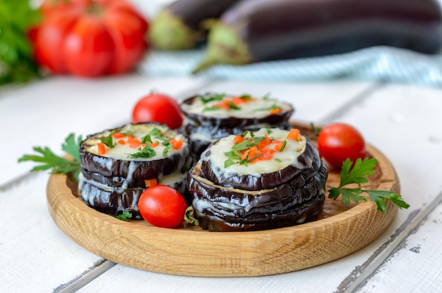 Eggplant baked with mozzarella cheese tomatoes on a wooden plate Vegetarian food recipe