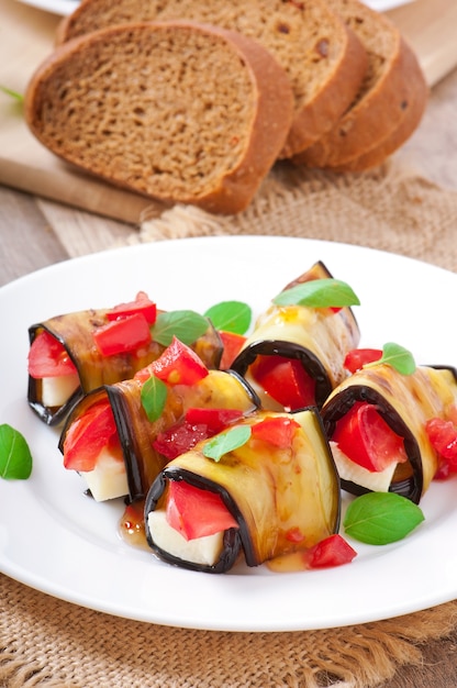 Eggplant rolls stuffed with cheese with a slice of tomato