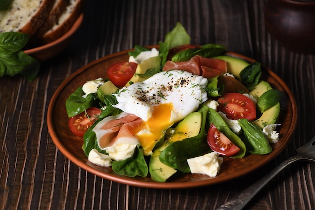 Eggs Benedict Poached Parma ham slices of avocado tomato and tender spinach leaves seasoned