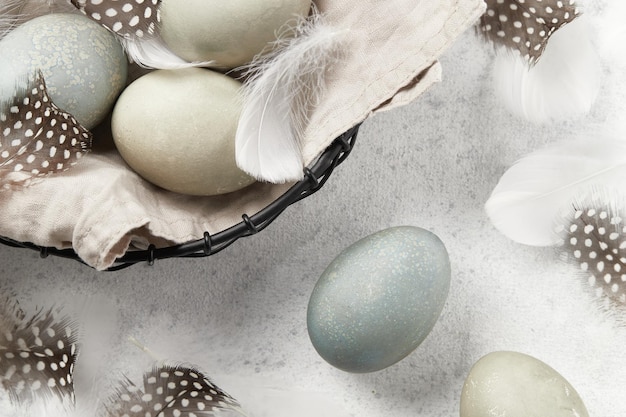 Photo eggs and feathers on a gray background easter celebration concept