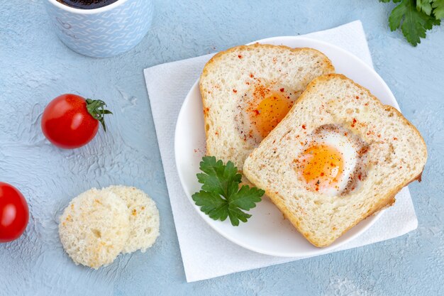 Eggs fried in cutout toasts on a plate