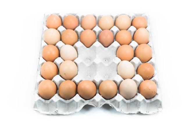 Eggs in paper tray on white backgroundBrown eggs in an egg carton