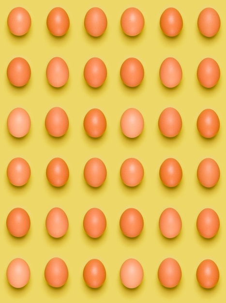 Eggs pattern on yellow background Easter concept Flat lay top view Food background