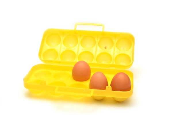 Eggs in a plastic container on white background