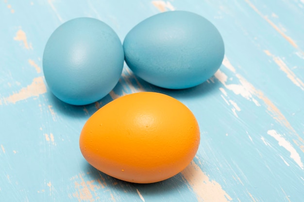 Eggs symbolizing the Easter holiday in blue and orange color on a background of aged wood