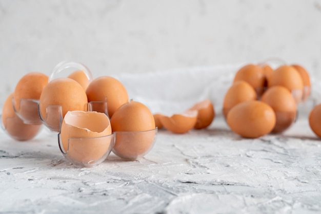 Eggs on the table with cracked in a half one, yolk and protein in opened egg, scrambled eggs cookings