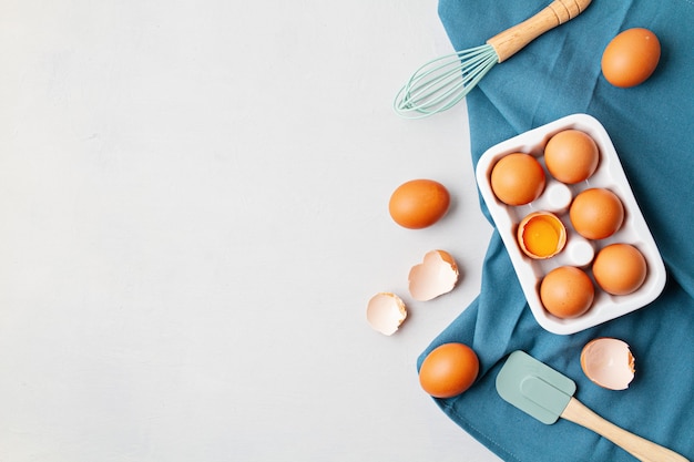 Eggs, towel in rustic style on light wall. Organic ingredient, healthy food lifestyle concept. Easter wall. Flat lay, copy space. Rustic table top view.