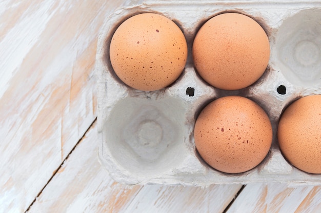 Eggs in a tray on white wooden table