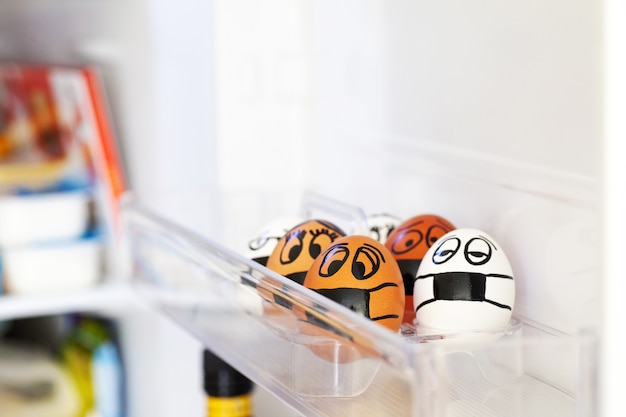 Eggs with different painted faces and medical masks