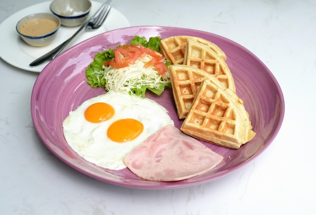 Eggs with ham and salad and belgian waffles close up