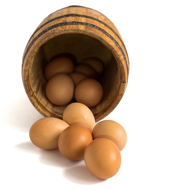 Eggs in wooden barrel on white background