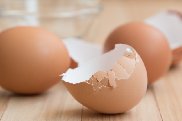 eggshell broke put near egg on wooden table background