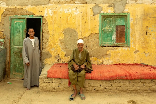 Egyptian men wearing traditional clothes near their old house