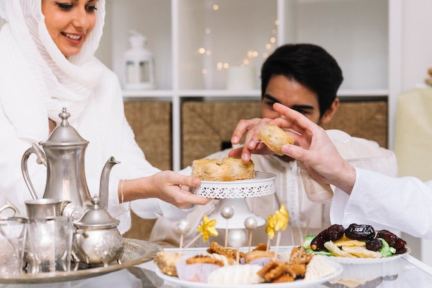 Eid al-fitr concept with people eating at table