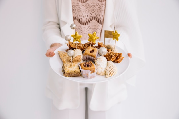 Eid concept with woman holding arab pastry