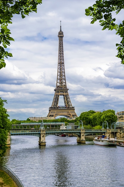 Eiffel tower on the background of the river Seine surrounded by leaves. Paris. France.