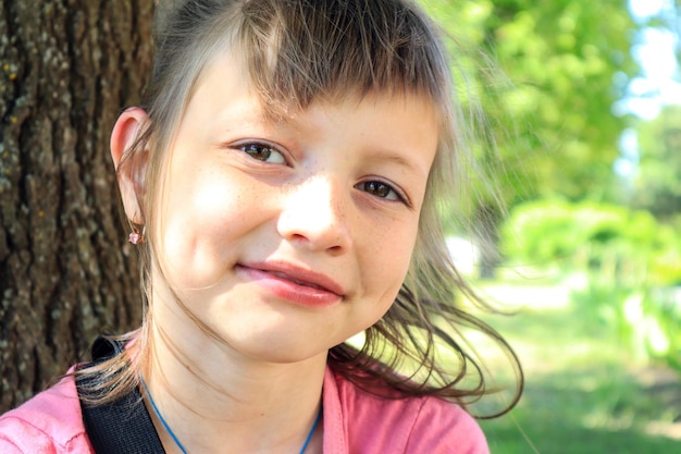 Eightyearold girl during a walk in the spring park outdoors closeup space for text