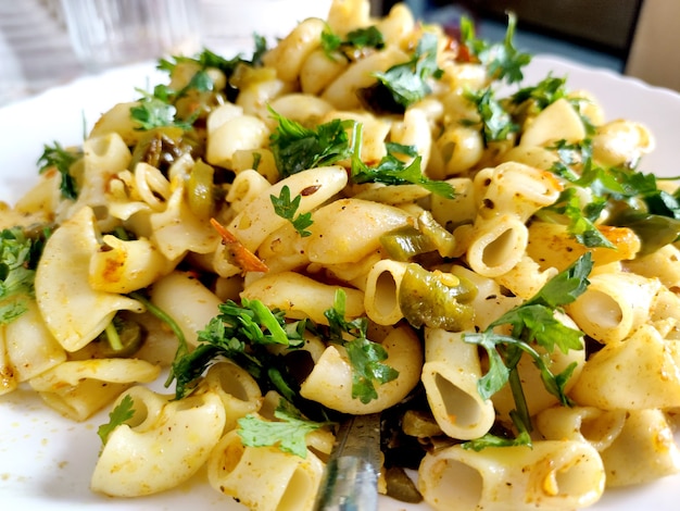 Elbow macaroni pasta with tomatoes, beans and parmesan on a plate close-up on the table. Horizontal