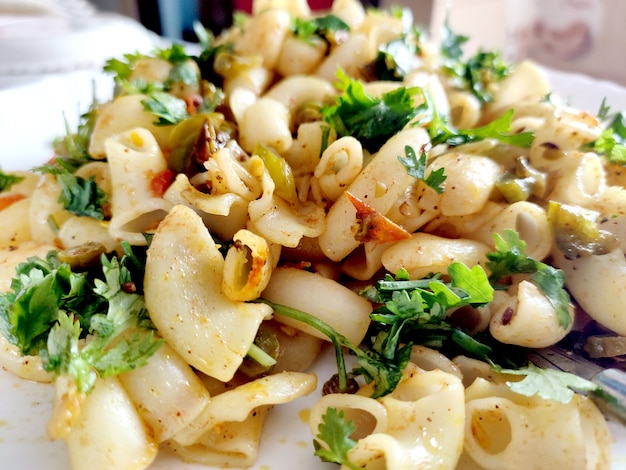 Elbow macaroni pasta with tomatoes, beans and parmesan on a plate close-up on the table. Horizontal