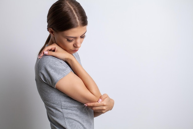 Elbow pain woman suffering from elbow pain on gray background