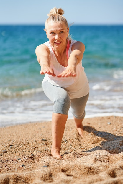 Elderly attractive woman during sports by the sea.