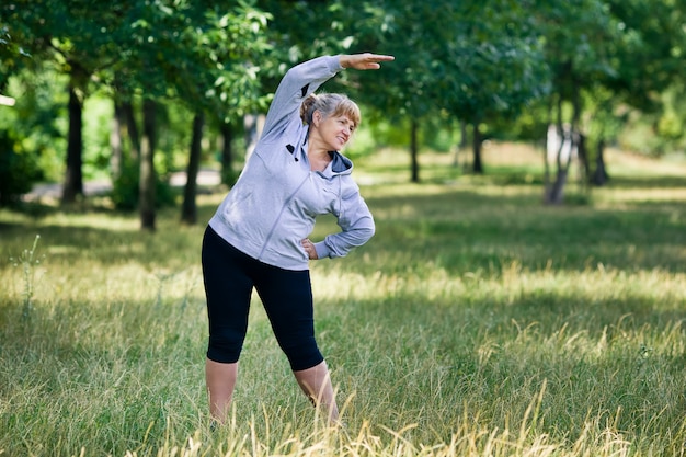 Elderly blonde woman working out in the park