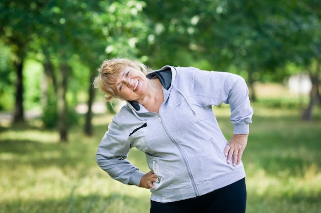 Elderly blonde woman working out in the park