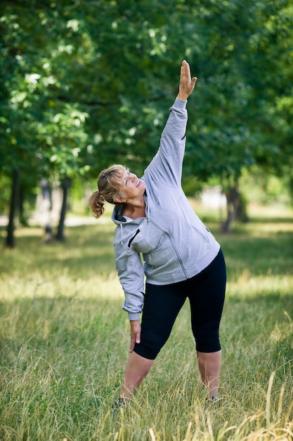 Elderly blonde woman working out in the park