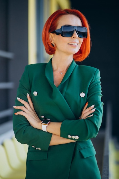 Elderly business woman outdoors wearing green suit