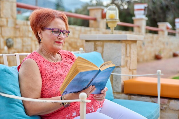 Elderly calm woman relaxing reading a book