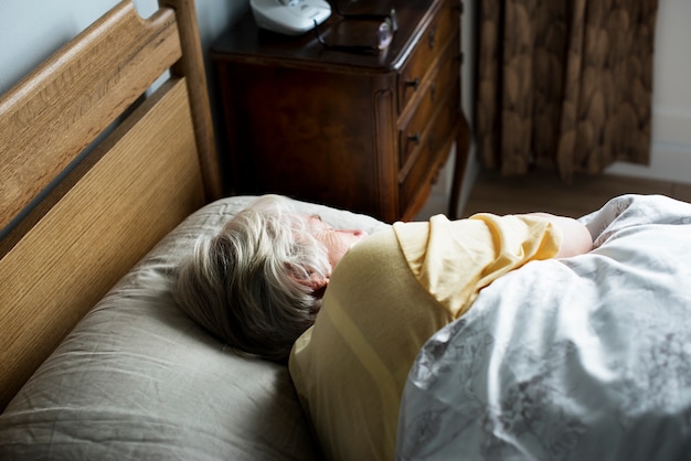 Elderly caucasian woman sleeping on the bed