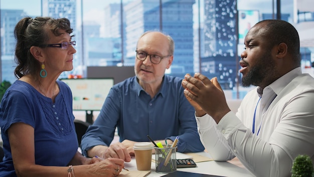 Elderly couple consulting with financial advisor to explore retirement plans