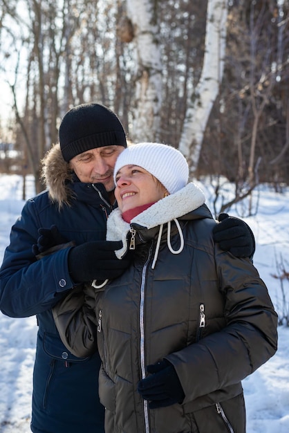 Elderly couple hugging each other in the countryside in the winter forest family relationship Life style closeup portrait vertical photo