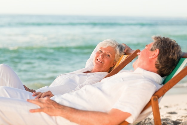 Elderly couple relaxing in their deck chairs