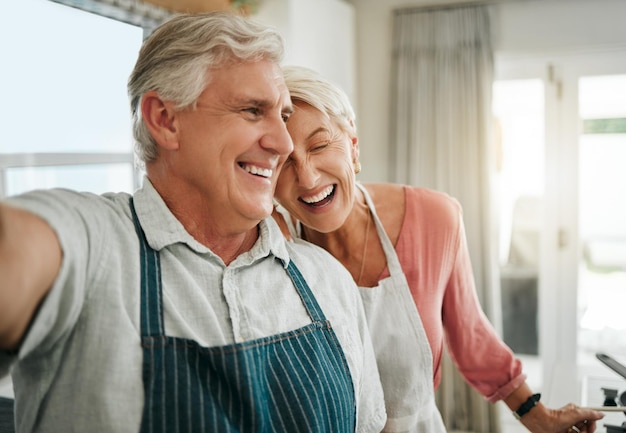 Elderly couple and selfie in home happy while cooking baking or cleaning together in funny moment Older man woman and retirement laughing in kitchen bonding and smile to make food and joke