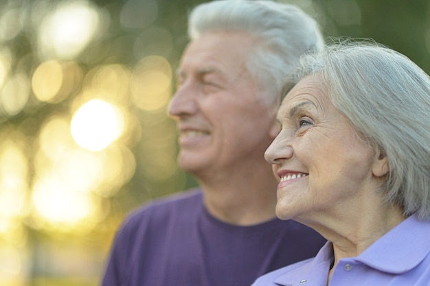 Elderly couple smilling together over natural background