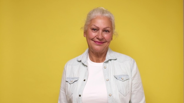 Photo an elderly european woman in glasses confidently looks into the camera smiling studio shot