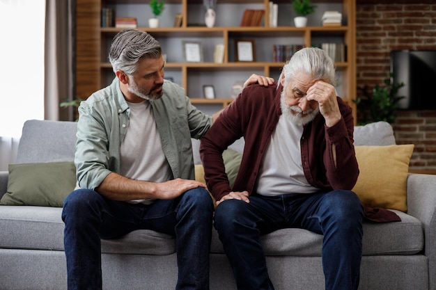 An elderly father complains about life to an adult son which help him to calm dawn Two generations family has conversation sharing news spending time together Understanding care and support